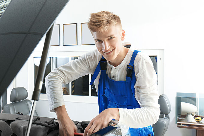 Ausbildung zum KFZ-Mechatroniker (m/w/d) Young mechanic repairing car in body shop